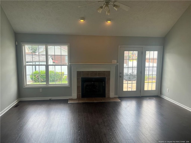 3418 Rudland Ct, Fayetteville, NC 28304 - unfurnished living room featuring a ceiling fan, dark wood-type flooring, a textured ceiling, lofted ceiling, and a tile fireplace