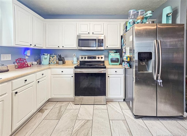 6314 Greycliff Dr, Fayetteville, NC 28314 - kitchen featuring appliances with stainless steel finishes, white cabinetry, light countertops, and a textured ceiling
