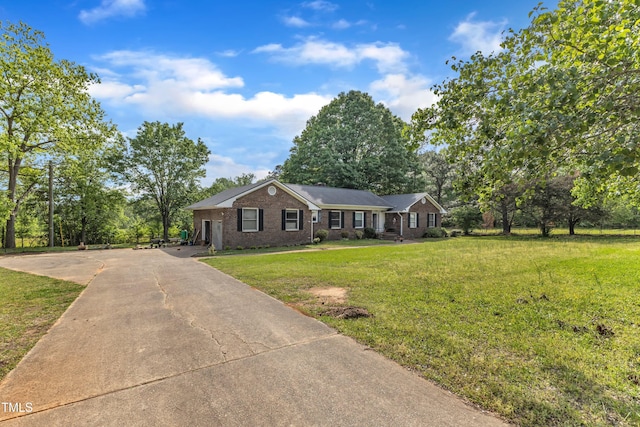 ranch-style house featuring concrete driveway, brick siding, and a front yard