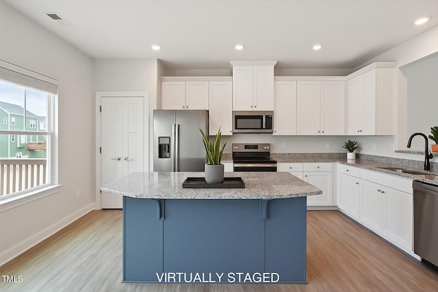 1073 Branch Line Ln, Apex, NC 27502 - kitchen with stainless steel appliances, a sink, light wood-style floors, a center island, and recessed lighting