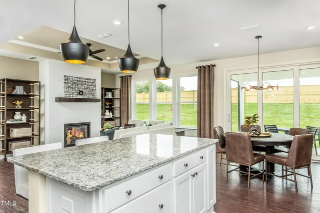 1606 Garden Park Cir, Fuquay Varina, NC 27526 - kitchen with white cabinetry, decorative light fixtures, a kitchen island, and dark wood finished floors