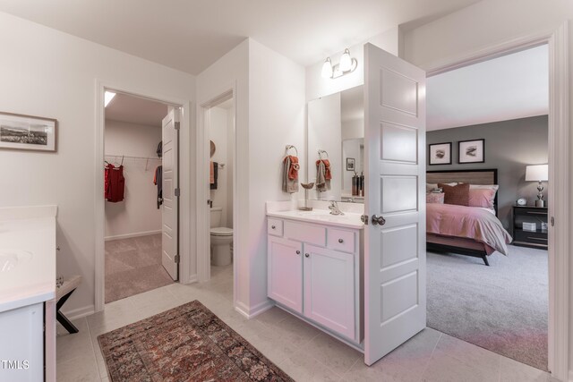 LOT5 Cooper St, Sanford, NC 27330 - ensuite bathroom with baseboards, toilet, tile patterned floors, vanity, and a walk in closet