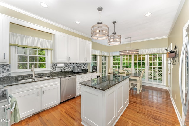 kitchen featuring dishwasher, a sink, backsplash, white cabinetry, and recessed lighting