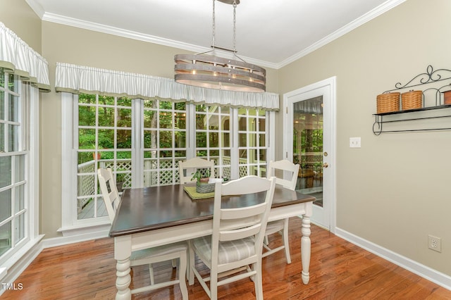 dining area with ornamental molding, wood finished floors, and baseboards