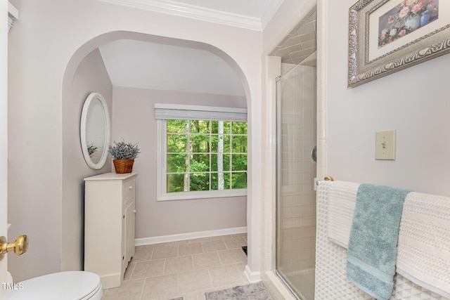 bathroom featuring a stall shower, toilet, tile patterned flooring, crown molding, and baseboards