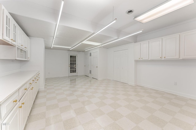 basement featuring baseboards and light flooring