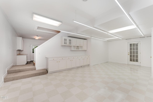 basement featuring light flooring and baseboards