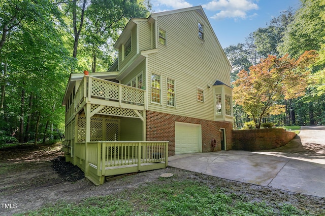 view of home's exterior with concrete driveway, an attached garage, and brick siding