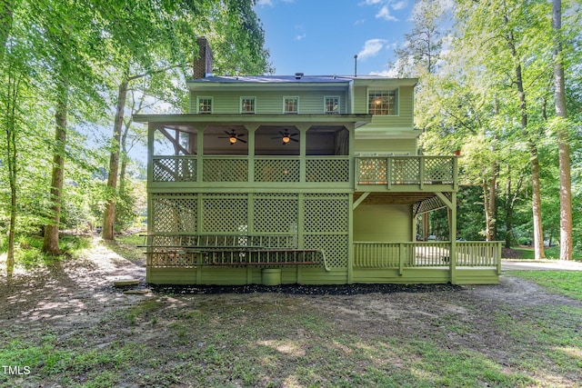 back of house featuring ceiling fan, a chimney, and a deck