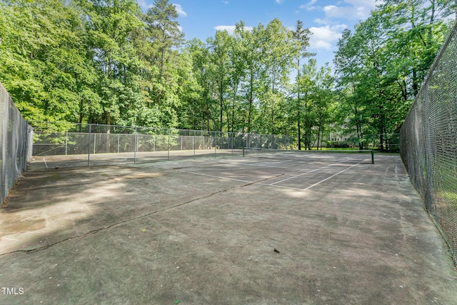 view of tennis court featuring fence