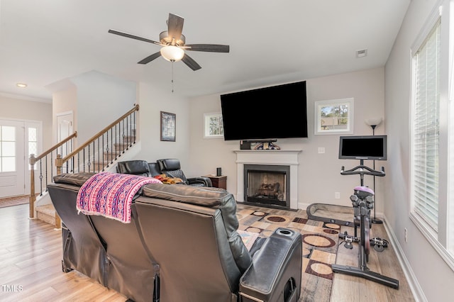 105 Forest Wood Dr, Salemburg, NC 28385 - living area featuring light wood-style floors, visible vents, a fireplace, a ceiling fan, and stairs