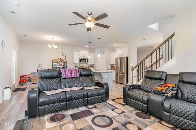105 Forest Wood Dr, Salemburg, NC 28385 - living area featuring stairway, light wood-style floors, visible vents, and ceiling fan with notable chandelier