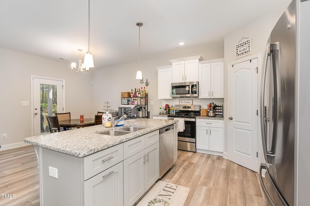 105 Forest Wood Dr, Salemburg, NC 28385 - kitchen featuring decorative backsplash, appliances with stainless steel finishes, light wood finished floors, a sink, and white cabinetry