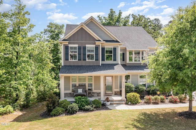 craftsman-style home featuring a porch, a shingled roof, board and batten siding, and a front yard