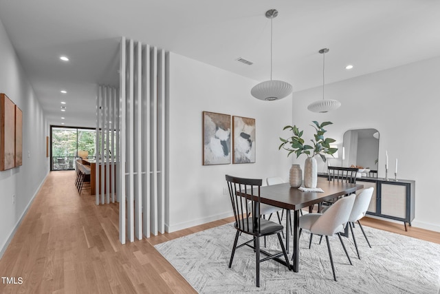 dining room featuring recessed lighting, arched walkways, visible vents, and light wood-style floors
