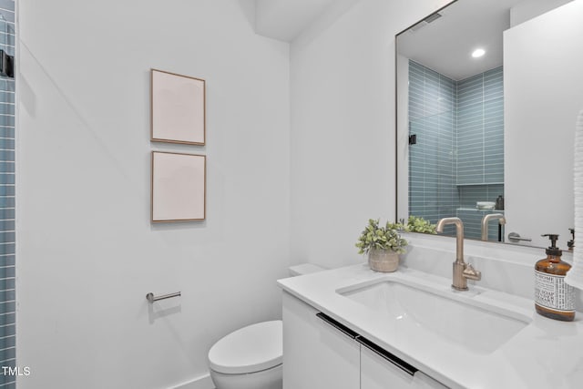 full bath featuring vanity, recessed lighting, a tile shower, and toilet