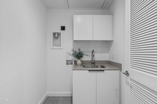 laundry room with a sink, hookup for an electric dryer, washer hookup, cabinet space, and dark tile patterned floors