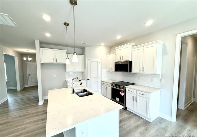 kitchen with white cabinets, appliances with stainless steel finishes, decorative backsplash, and a sink