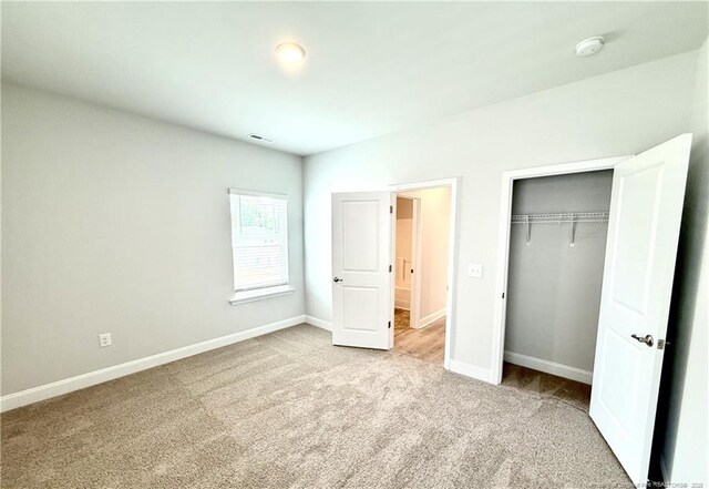 unfurnished bedroom featuring baseboards, a closet, and carpet flooring