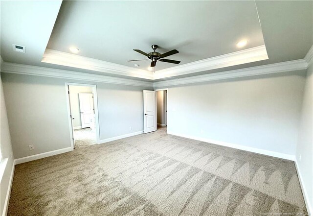 unfurnished bedroom featuring crown molding, visible vents, a raised ceiling, and baseboards
