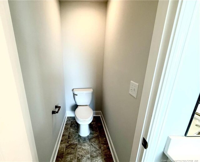 bathroom with toilet and baseboards