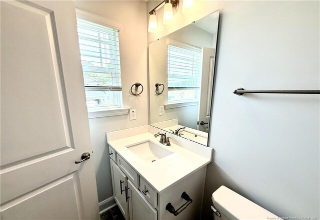 half bathroom featuring toilet and vanity