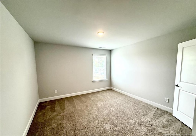 unfurnished room with carpet floors and baseboards