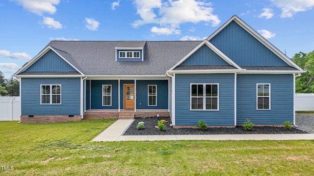 view of front of property with fence, a shingled roof, a porch, and a front lawn