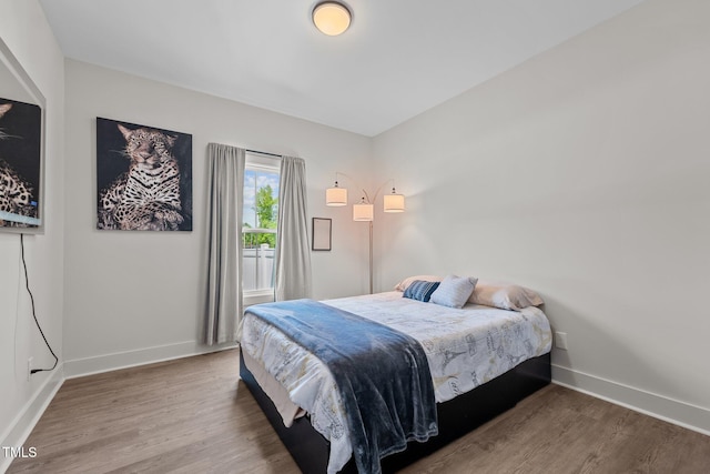 bedroom with baseboards and wood finished floors