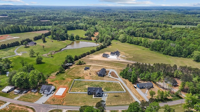 aerial view with a water view and a wooded view