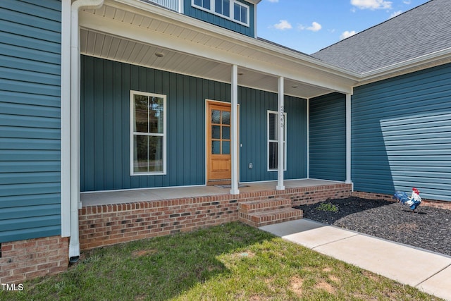 view of exterior entry with covered porch and roof with shingles