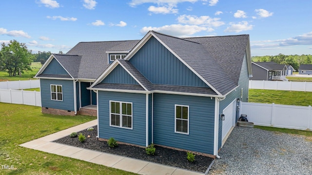 exterior space featuring roof with shingles, board and batten siding, a fenced backyard, and a front lawn