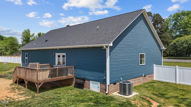 rear view of house with a lawn, a deck, cooling unit, and fence