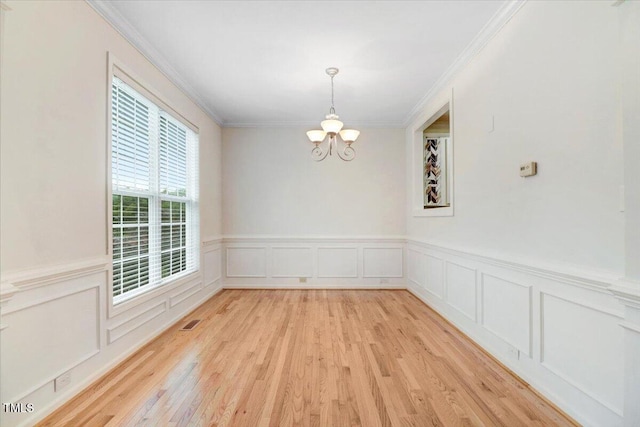 1480 Big Leaf Loop, Apex, NC 27502 - empty room with a chandelier, light wood-style flooring, ornamental molding, a wainscoted wall, and a decorative wall