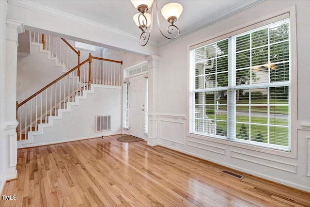 1480 Big Leaf Loop, Apex, NC 27502 - entrance foyer with ornate columns, stairway, light wood-type flooring, ornamental molding, and a wainscoted wall