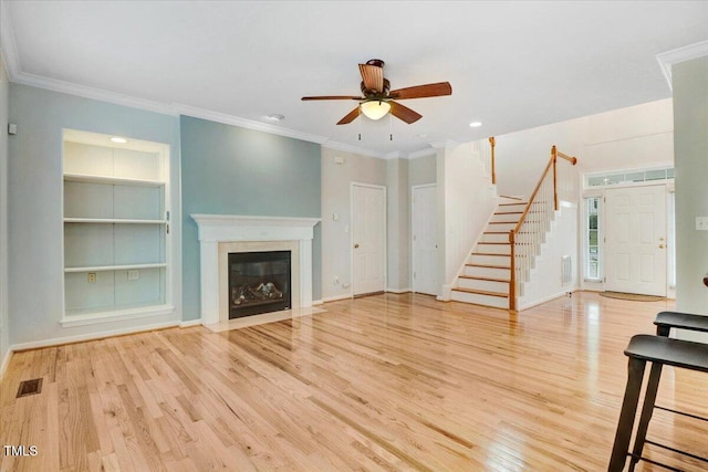 1480 Big Leaf Loop, Apex, NC 27502 - unfurnished living room featuring stairs, wood finished floors, ceiling fan, built in features, and baseboards