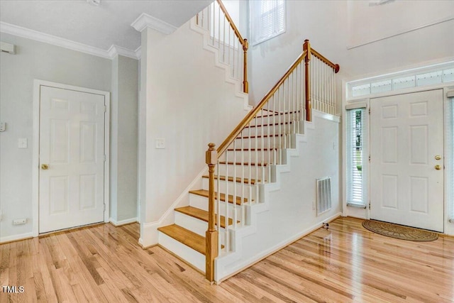 1480 Big Leaf Loop, Apex, NC 27502 - entryway with ornamental molding, wood finished floors, stairs, and baseboards