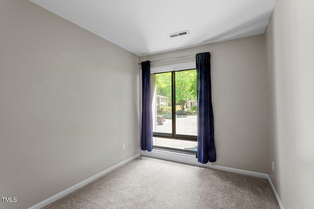 unfurnished room with carpet floors, baseboards, and visible vents