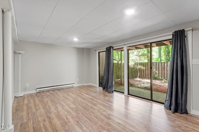 unfurnished room featuring recessed lighting, baseboards, a baseboard heating unit, and wood finished floors