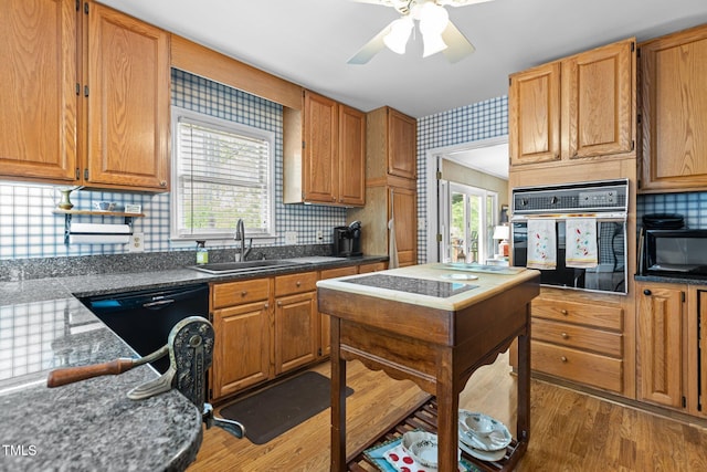 113 Denard St, Oxford, NC 27565 - kitchen featuring wood finished floors, black appliances, backsplash, a sink, and a ceiling fan