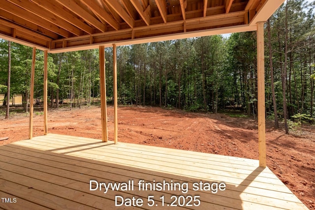 wooden terrace featuring a wooded view