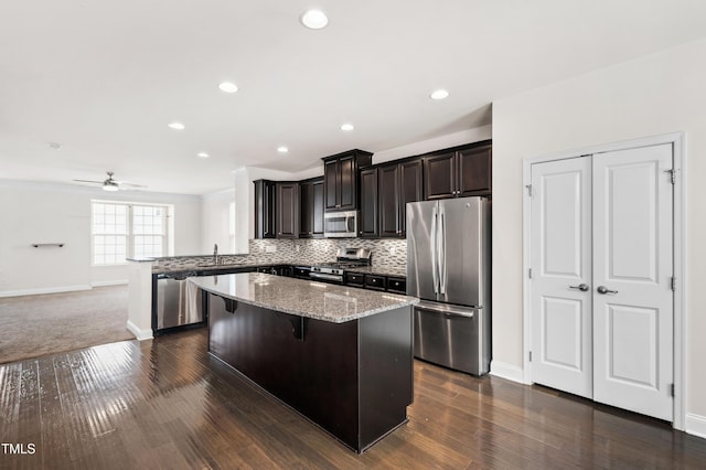 1101 Boxcar Way, Apex, NC 27502 - kitchen with stainless steel appliances, baseboards, a sink, a breakfast bar area, and a center island