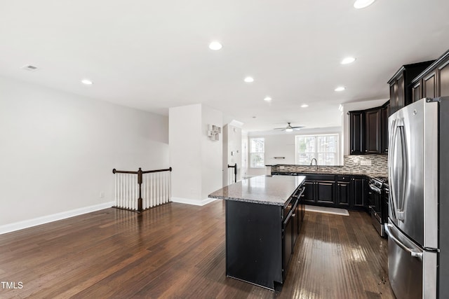 1101 Boxcar Way, Apex, NC 27502 - kitchen with stainless steel appliances, a center island, dark wood-type flooring, light stone counters, and recessed lighting