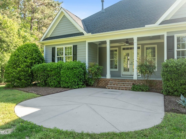 rear view of property featuring a porch, a ceiling fan, and roof with shingles