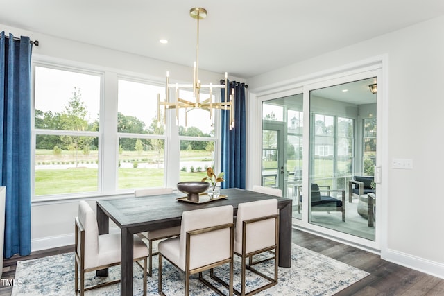 dining space with a wealth of natural light, baseboards, a notable chandelier, and dark wood-type flooring
