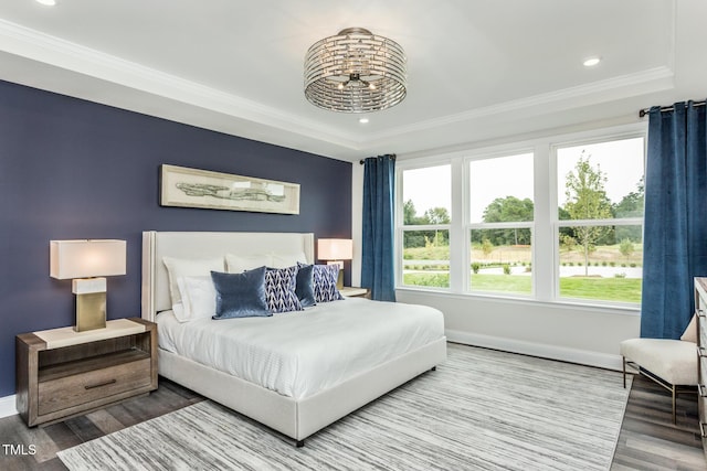 bedroom featuring baseboards, recessed lighting, a raised ceiling, and wood finished floors