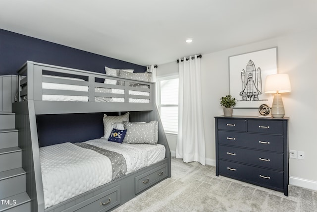 bedroom featuring light carpet and baseboards