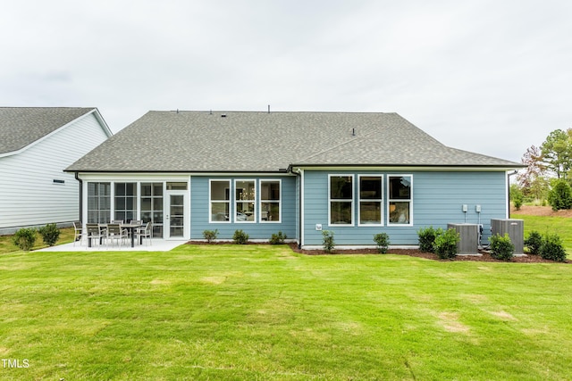 rear view of house featuring cooling unit, roof with shingles, and a patio area