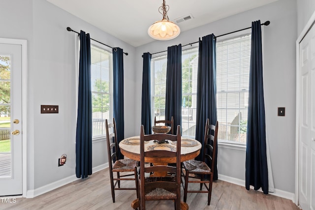 dining area with light wood-style floors and baseboards