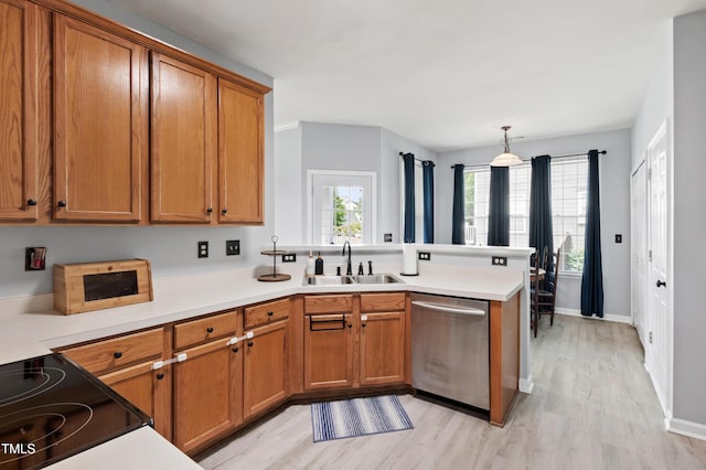 kitchen featuring dishwasher, a sink, a peninsula, light wood-type flooring, and brown cabinetry